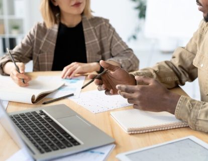 gros-plan-collegues-multiethniques-assis-table-papiers-appareils-discutant-du-projet-demarrage_274679-13860